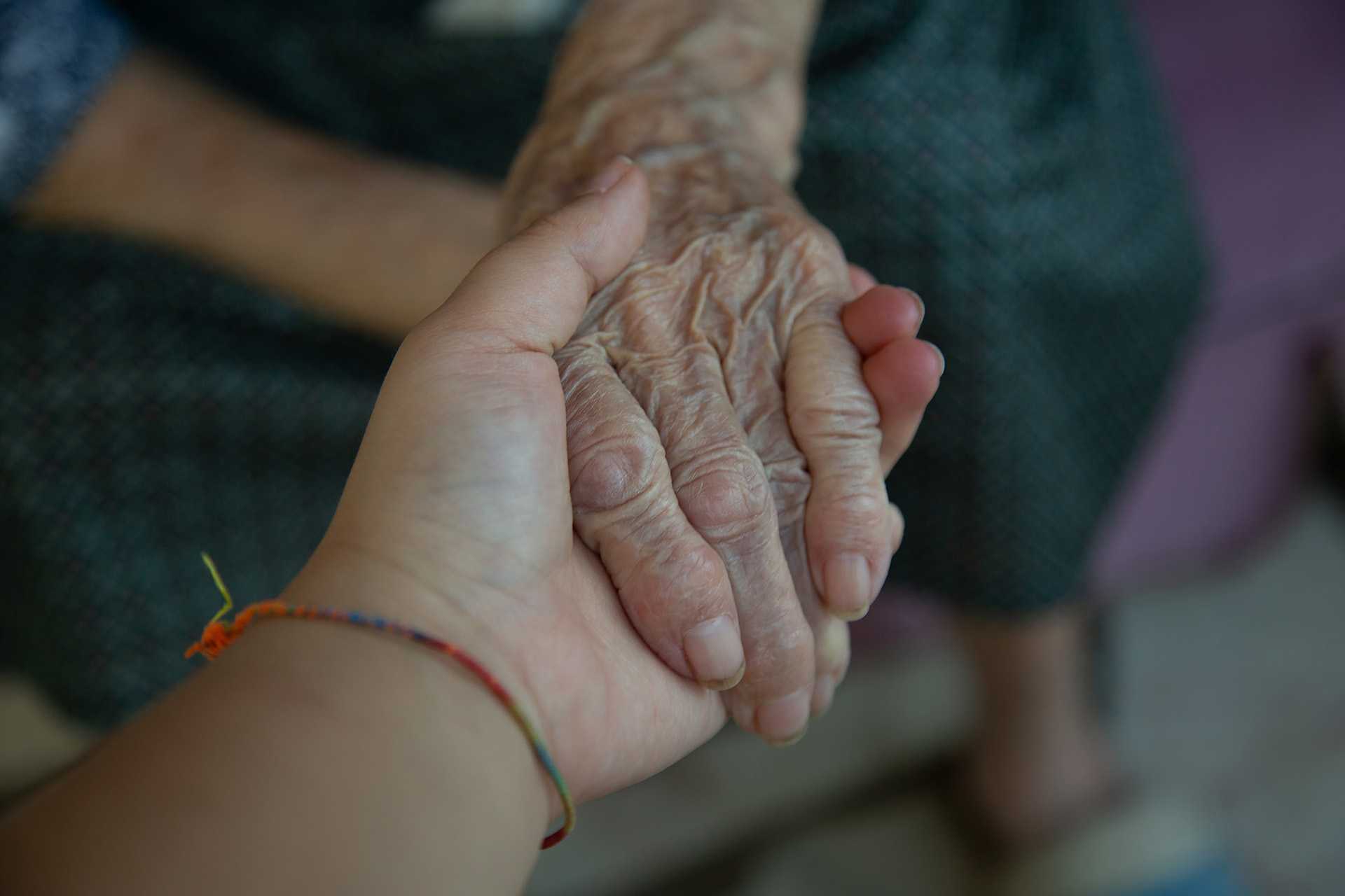 Great grandmother and great granddaughter holding hands