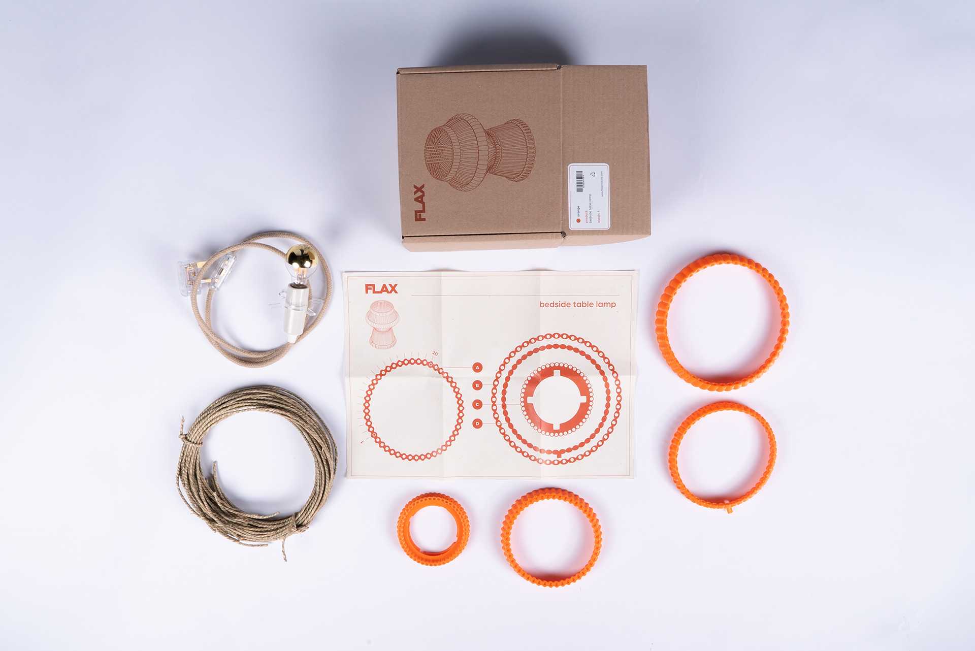 The FLAX kit unpacked, displaying its various components and step-by-step instructions for assembling your own basket lamp.